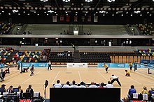 Two teams playing goalball. Each team has three people on it.