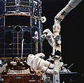 Closer look at repair, astronauts are anchored to the Shuttle's robotic arm