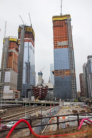 The future New York sightseeing object is surrounded by new skyscrapers (photo) above West Side Rail Yard, with a view up to the investors, inhabitants and investments from the public park near the Hudson river.