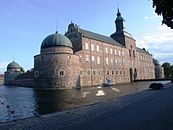 Vadstena slott med postejer. Tornhuvarna har tillkommit senare.