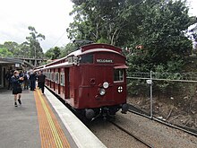 An old train that is red at a station