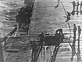 Enterprise crewmen inspect and begin to repair the damage from the third bomb to hit the flight deck during the attack on August 24, 1942.