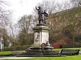 Statue on stone base in parkland