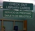 Teksaso (Usono), biblioteka ŝildo en la angla kun la hispana malsupre. La urbo havas multajn hispanparolantojn, do la publika biblioteko aldonis hispanajn librojn kaj hispanajn ŝildojn.