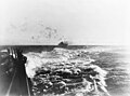 USS Enterprise under attack by Japanese dive bombers on August 24, 1942. The ship is on fire and anti-aircraft shell bursts can be seen over the carrier.