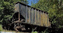 Coal car sitting above a mural depicting various 18th- and 19th-century artists, as well as the text, “We are all different flowers from the same garden”