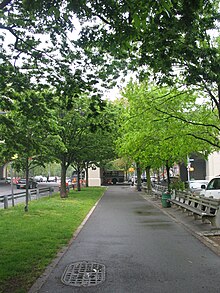 A walking path near the southern end of the parkway. There are trees and benches alongside the path.