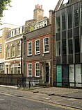 A brown brick house with large white rectangular windows.