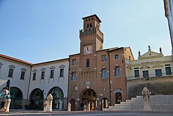 Il Torresin, che prospetta su Piazza Grande al pari di altri monumenti opitergini quali il Duomo di San Giovanni Battista, la Loggia Comunale, il Torresòn ed altri edifici storici, tra cui il Palazzo Saccomani e lo storico Caffè Commercio.