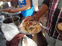 Dahi puri servis sur un stand.