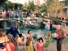 A picture of a pool party with many people scattered around, engaged in various activities.