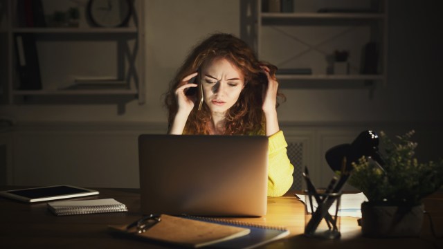 Article thumbnail: Upset woman talking on phone while working on laptop, sitting at her working place at home, copy space