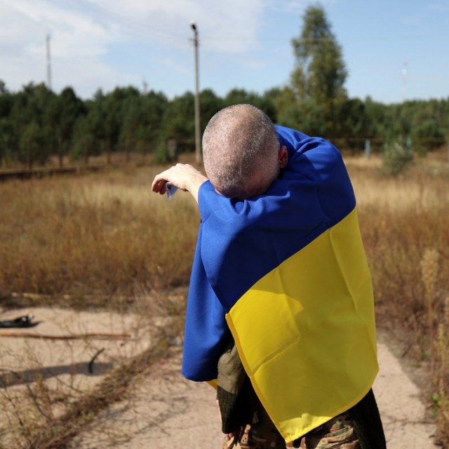 Article thumbnail: A Ukrainian serviceman wrapped in a Ukrainian flag reacts after being released from Russian captivity at an undisclosed location near the Ukrainian-Belarusian border, on September 13, 2024, amid the Russian invasion in Ukraine. 49 Ukrainian prisoners of war, including soldiers of the armed forces of Ukraine, the National Guard, the national police, the state border guard service, as well as fighters from Mariupol's 2022 Azvostal battle, had been returned to their country from Russia on September 13, 2024. (Photo by Anatolii STEPANOV / AFP) (Photo by ANATOLII STEPANOV/AFP via Getty Images)