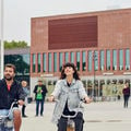 Students riding bikes in front of the Aalto University Väre building, photo by Unto Rautio