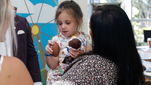 Raleigh Reid, 3, admires toys given to her by Pro and College Football Hall of Famer Champ Bailey at Children’s Healthcare of Atlanta Egleston on Tuesday, Aug. 27, 2024. Egleston is moving all of its patients to the new Arthur M. Blank Hospital. (Natrice Miller/ AJC)