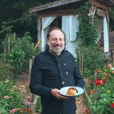 Executive chef and owner Mark Henegan of the Bush Farmhouse poses in the restaurant's garden with a bowl of his South African-inspired hoppin' John. (Grace Dickinson for The Atlanta Journal-Constitution)