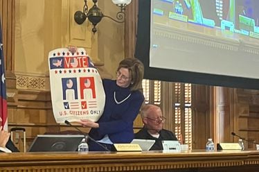 State Election Board member Janice Johnston holds up a sign encouraging only U.S. citizens to vote during a State Election Board meeting Wednesday at the Georgia Capitol in Atlanta. The board voted 3-1 to email the sign to all 159 counties, encouraging election officials to post the sign at polling locations and election offices. Voting rights groups say they’re concerned the sign could discourage immigrants who have become citizens from registering to vote in a state that already has stringent voting laws.