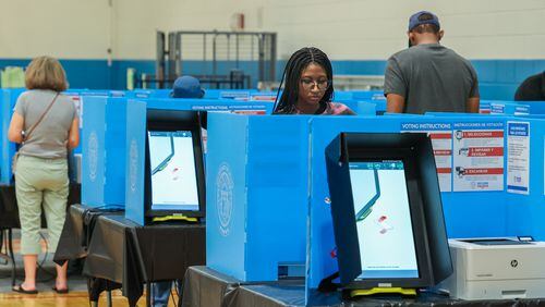 Mariama Dabo (CQ-foreground) casts her ballot at Rhodes Jordan Park in Lawrenceville. PHIL SKINNER FOR THE ATLANTA JOURNAL-CONSTITUTION