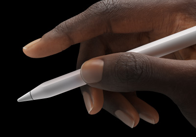 Seorang pengguna memegang Apple Pencil Pro di antara ibu jari dan telunjuknya.