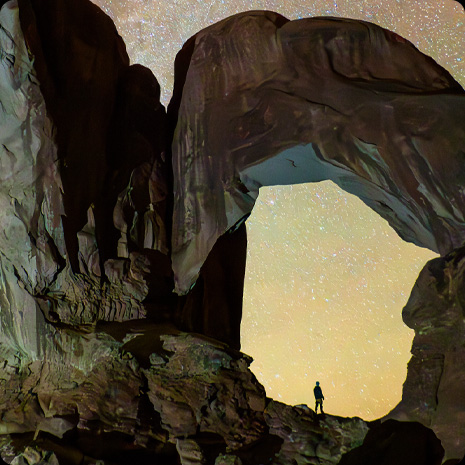 Asmens, esančio kanjone žvaigždėto naktinio dangaus fone, nuotrauka