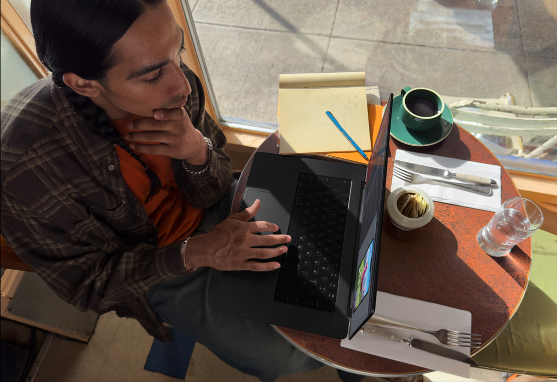 Photo d’une personne pendant une séance photo en train de retoucher ses photos sur son MacBook Pro.