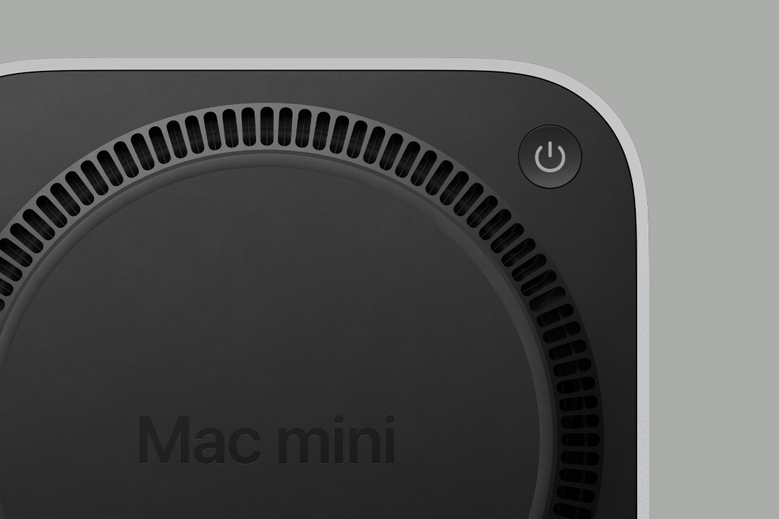 Mac mini’nin güç düğmesini ve fan benzeri dairesel havalandırma mimarisini gösteren siyah alt kısmı