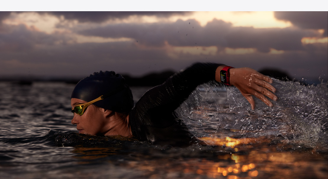 A woman wearing Apple Watch Series 9 while swimming outdoors in water.