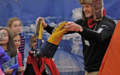 A man and a group of children testing out cold weather clothing