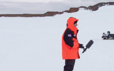 A film crew interviewing a man in an icy landscape