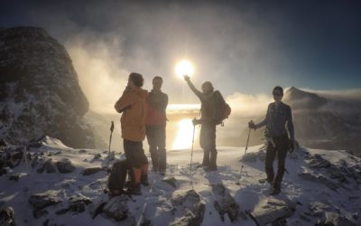 A group of people standing on top of a snow covered slope.