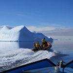 A group of people in a boat on a body of water.