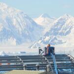 A building being constructed by the side of a snowy mountain