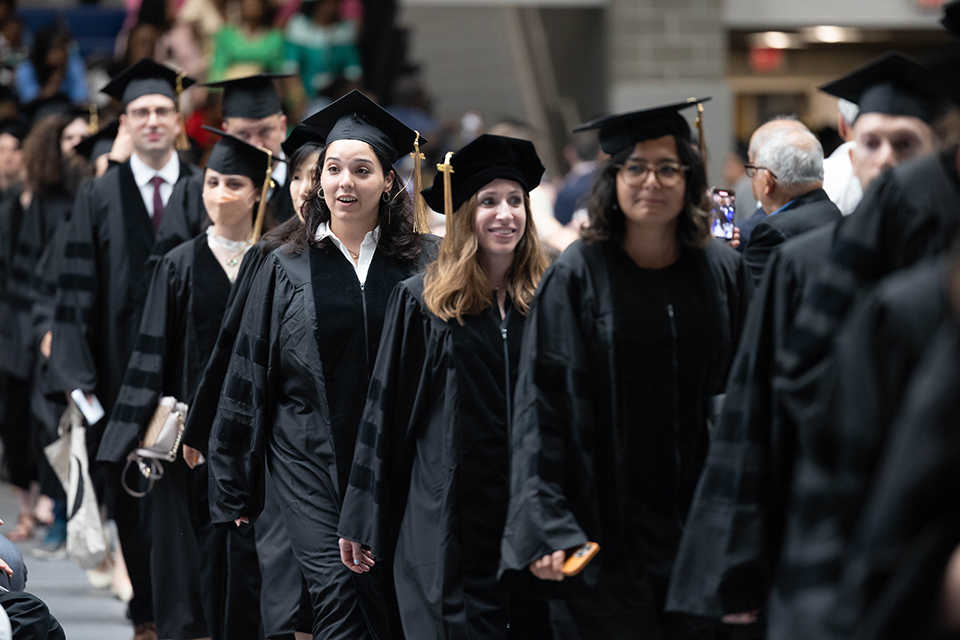 GSAS students, in robes, march at the 2023 Commencement.