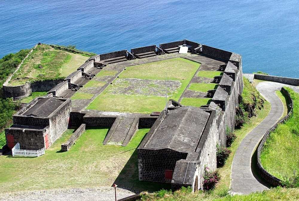 Brimstone Hill Fortress National Park on a hill on St. Kitts is home to one of the best-preserved 17th and 18th century fortifications in the Americas. The fortress, designed by the British and built by African slave labor, is an example of colonial expansion and African slave trade in the Caribbean. Brimstone Hill Fortress is virtually a man-made outgrowth of the natural hill.  St. Kitts was the first Caribbean Island permanently settled by both the English and the French who shared the island between 1627 and 1713 and battled often for control of the fort until the 1783 Treaty of Paris restored St. Kitts and Nevis and Brimstone Hill to British rule.  Brimstone Hill Fortress National Park became a UNESCO site in 1999.