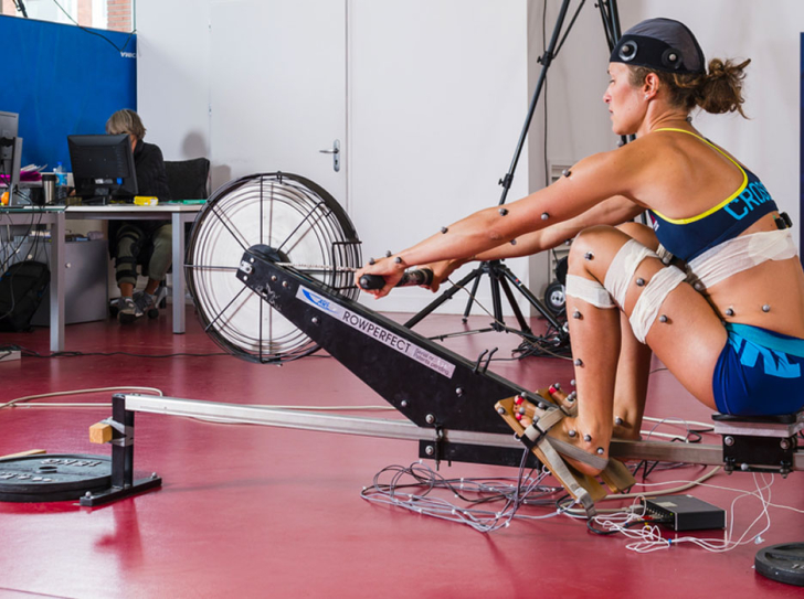 Sportive équipée de capteurs pour enregistrer ses mouvements en pratiquant l'aviron