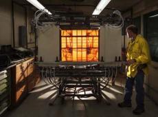 demonstrates use of the glowing radiant panel. Surrounded by reflections from elliptical mirrors, the panel allows researchers to examine the effects of radiant heat on ignition rates.