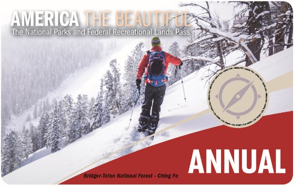 A picture of the America the Beautiful annual pass that has a person snowshoeing on the side of a mountain.