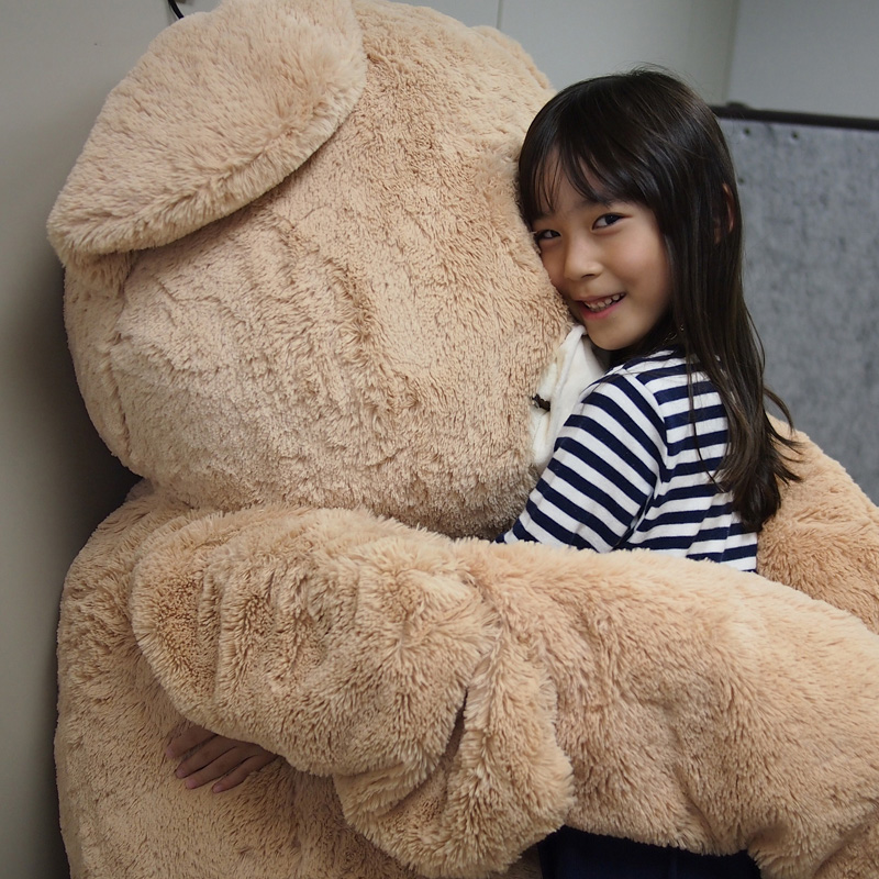 A child being hugged by a robot