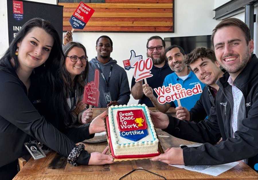 Certification Nation Day 2024 Wrap-up: Showcasing Company Culture Through Certification A group of eight smiling employees proudly hold a cake with a
