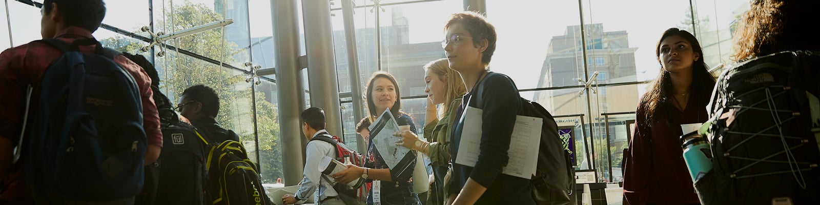 Banner image of students walking through brightly lit lobby during Orientation.