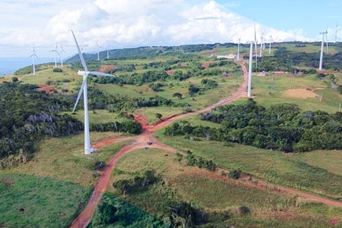 Aereal view of some windmills in a field. IDB