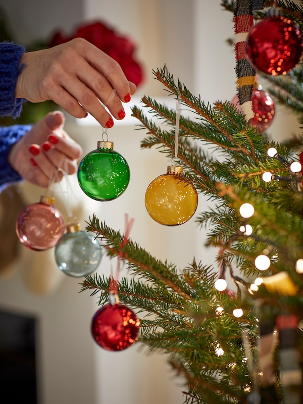 Des boules de Noël colorés VINTERFINT accrochés au sapin de Noël.