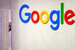 An employee closes the door of the back office next to a Google logo at the Google stand at Hannover Messe 2024