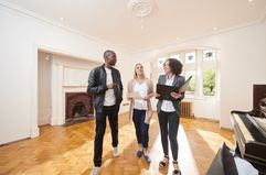 An estate agent shows a couple around a refurbished period home