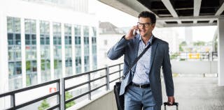 Small business owner talking on his cell phone while walking through a parking garage