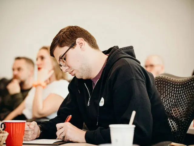 man sitting and writing 