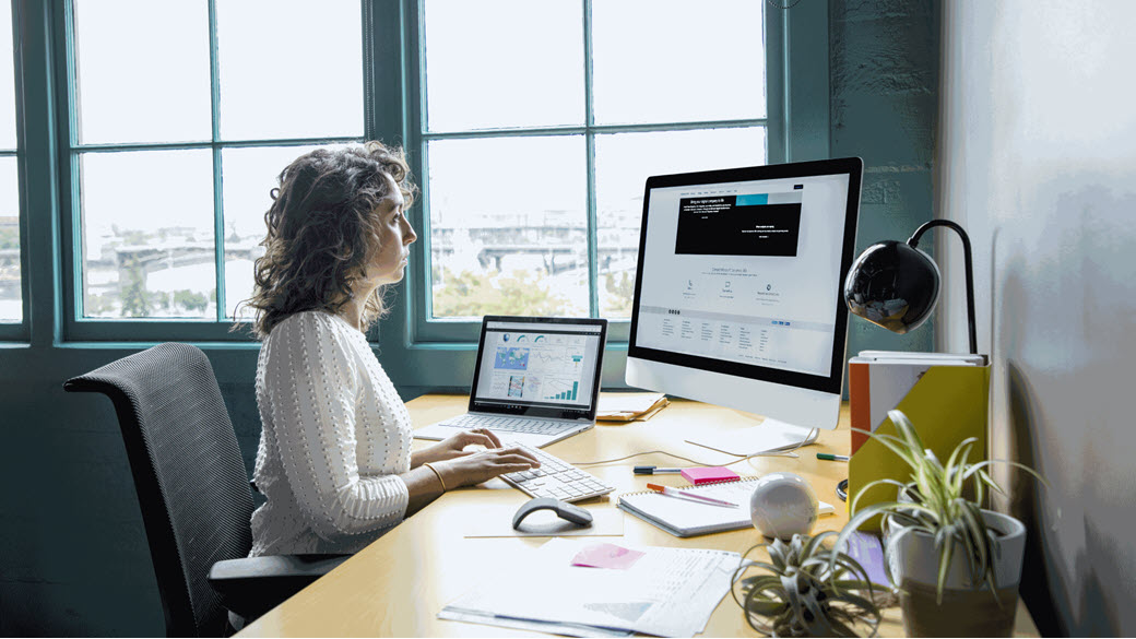 Woman sitting at a desk using a computer.