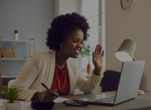 Happy woman working at laptop with hand raised