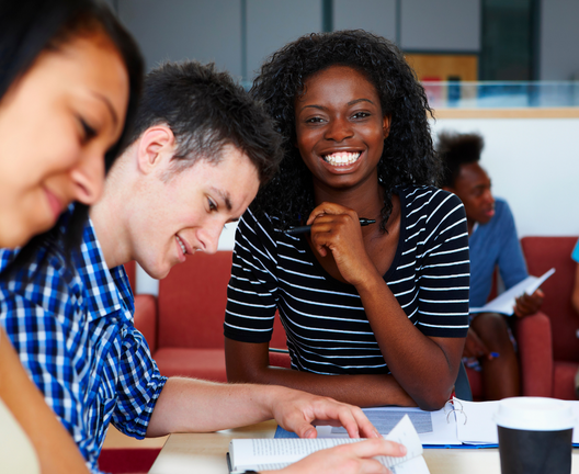 Student smiling and another student reading