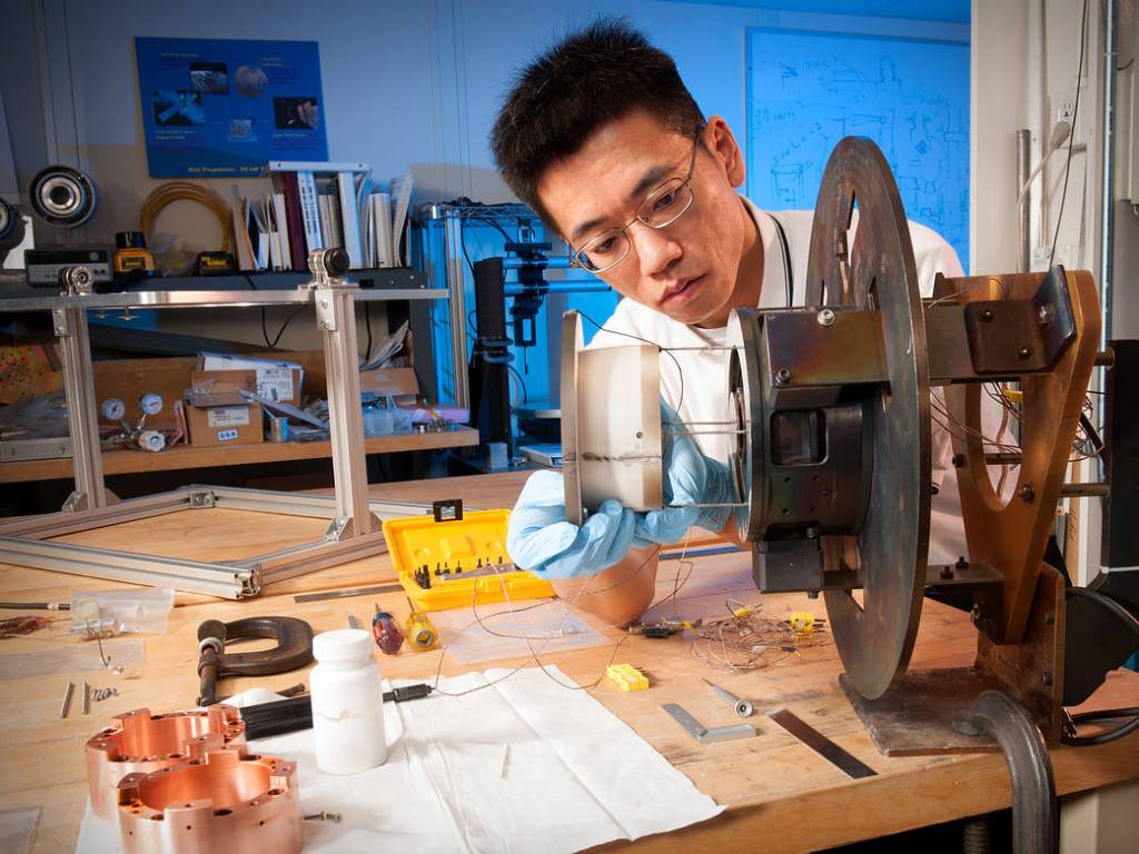 picture of NASA scientist in front of a hull thruster experiment